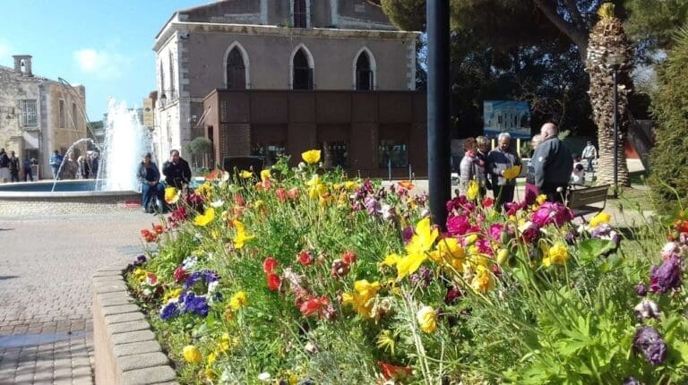 Massif de fleurs colorées devant un bâtiment ancien à Balaruc