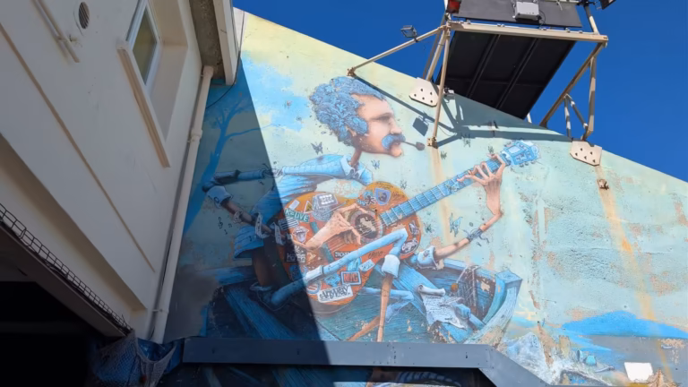 Fresque murale d'un musicien à la guitare au Théâtre de la Mer à Sète, vue depuis le bas