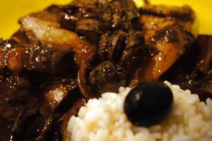 Daube de seiches au vin rouge servie avec du riz et une olive noire