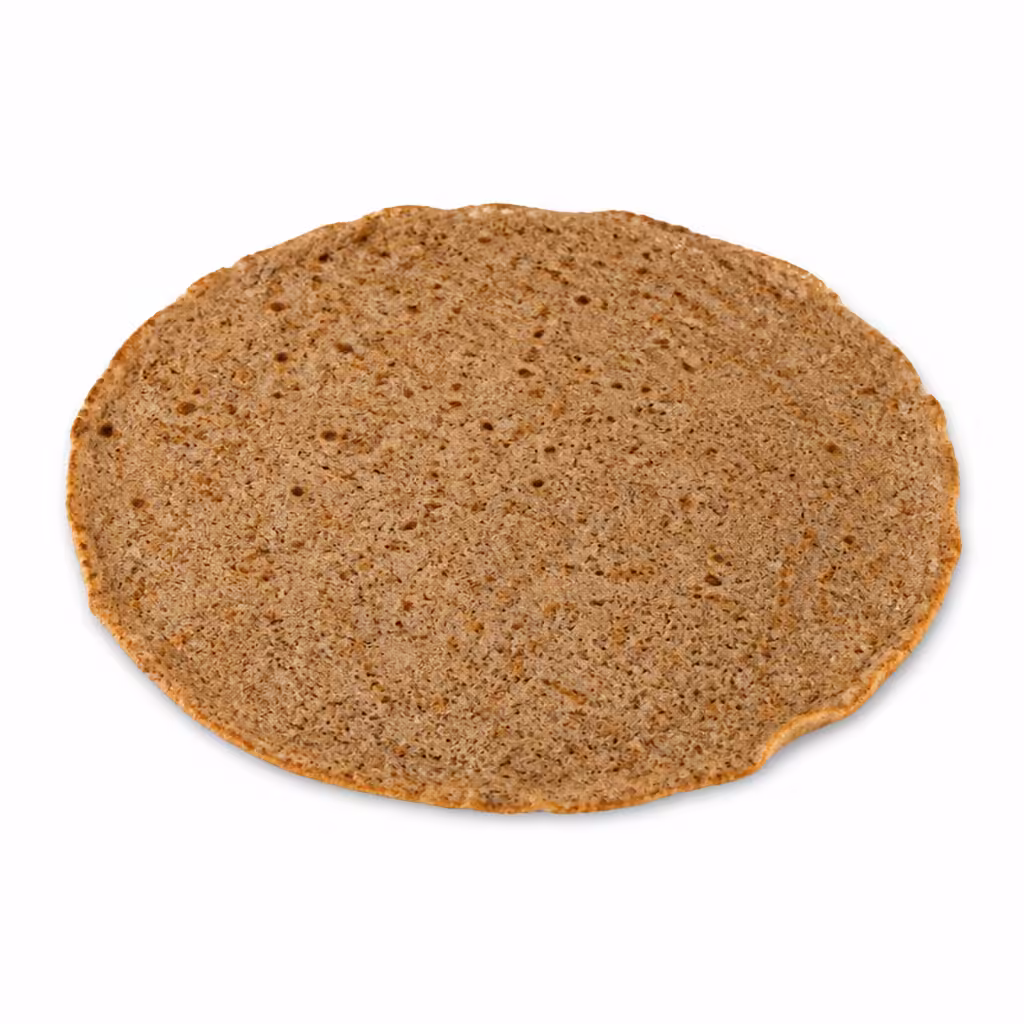 Galette de sarrasin ronde et fine brun grisé sur fond blanc