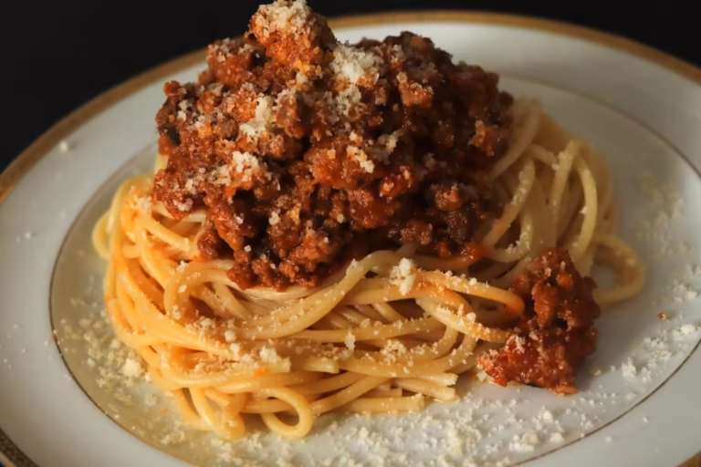 Assiette de spaghettis au ragù bolognaise saupoudrés de parmesan