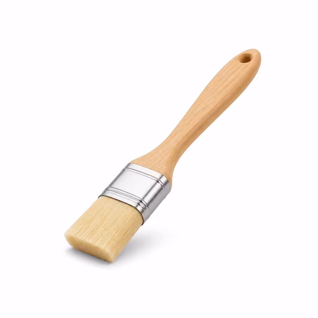Pinceau de cuisine à manche en bois clair sur fond blanc